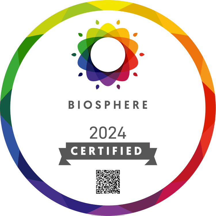 Badge circulaire avec une bordure géométrique colorée, une fleur abstraite multicolore et le texte 